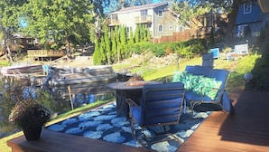 A deck with outdoor furniture, a small table, and a potted plant.