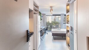 A modern kitchen with a dining area, a built-in fridge, and a view of the city. - ON Augusta (São Paulo)
