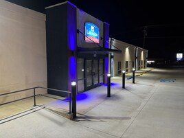 Exterior de hotel à noite com letreiros iluminados para 'LakeSide Inn & Suites' e 'Physio & Wellness'.