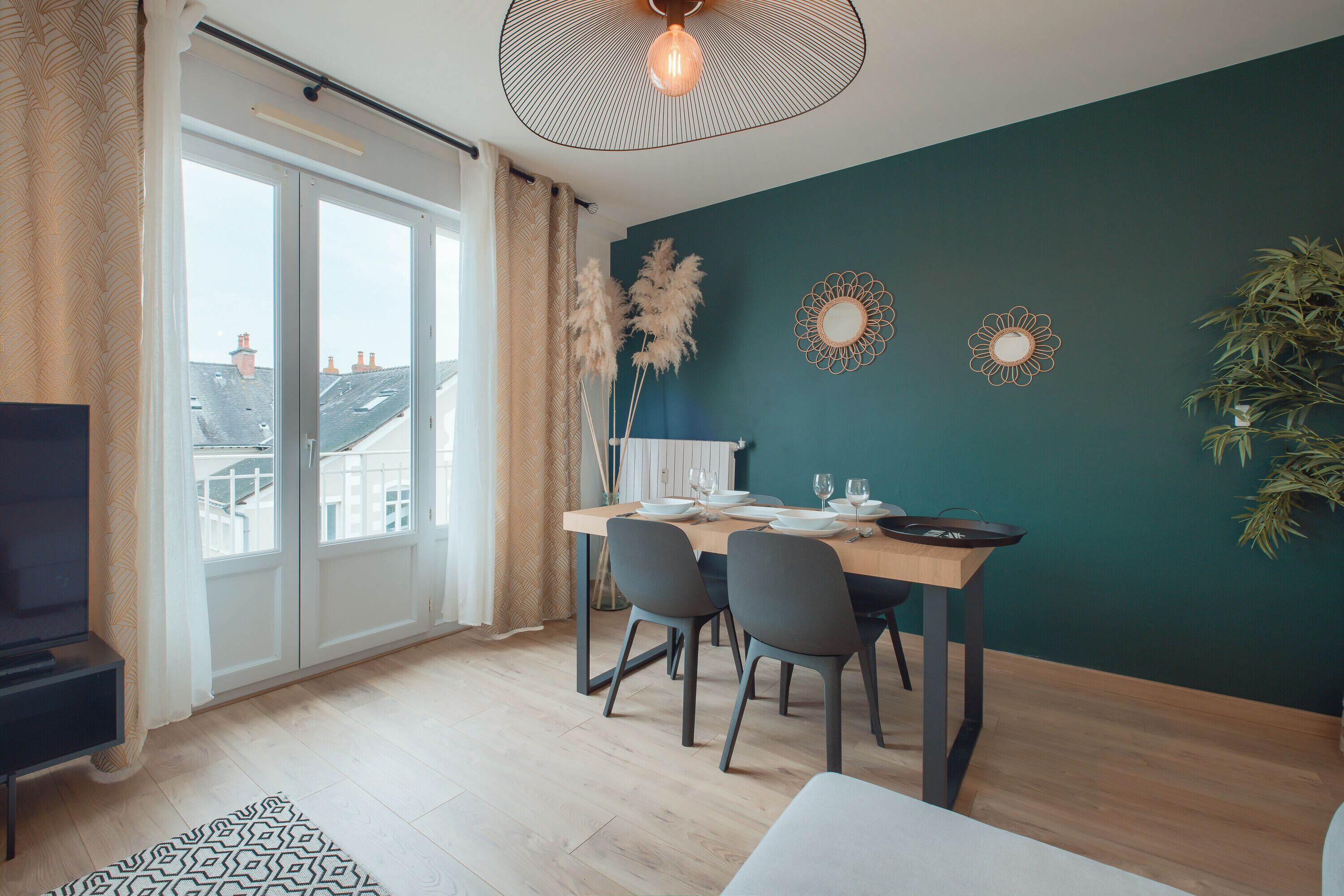 Un espace repas moderne avec une table en bois, des chaises et des œuvres d’art décoratives au mur.