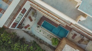 An aerial view of a residential property with a swimming pool, multiple windows, and a garden area. - LaFamilia Casa and Suites (Isla Holbox)