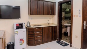 Una cocina compacta con microondas, refrigerador y pileta.