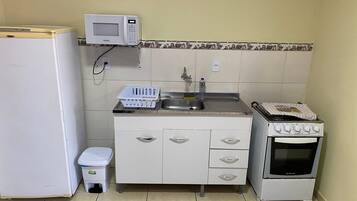 Studio | Privékeuken | Een koelkast, een microgolfoven, een oven, kookgerei, borden en bestek