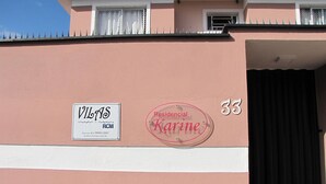 Μια πρόσοψη κτιρίου με μια επιγραφή που αναγράφει «VILAS RCM» και το λογότυπο «Karine», υποδεικνύοντας ότι πρόκειται για ένα οικιστικό ακίνητο.