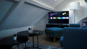 Ett modernt vardagsrum med tv, soffa och soffbord.