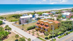 Zona residencial costera con casas, una playa y una vista despejada del océano.