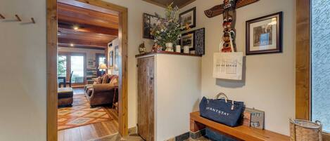 Een houten receptiebalie met een bloevas, een totempaal, ingelijste foto's en een 'WantStay' tas.