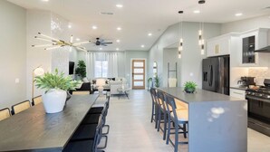 A modern kitchen with a central island, built-in appliances, and pendant lighting. - Calypso by Avantstay Entertainers Paradise Pool, Hot Tub, Putting Green (Indio)