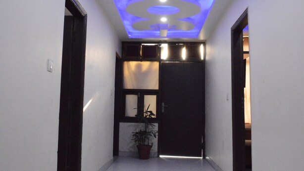 Un pasillo con un diseño moderno en el techo, que incluye patrones circulares e iluminación empotrada.