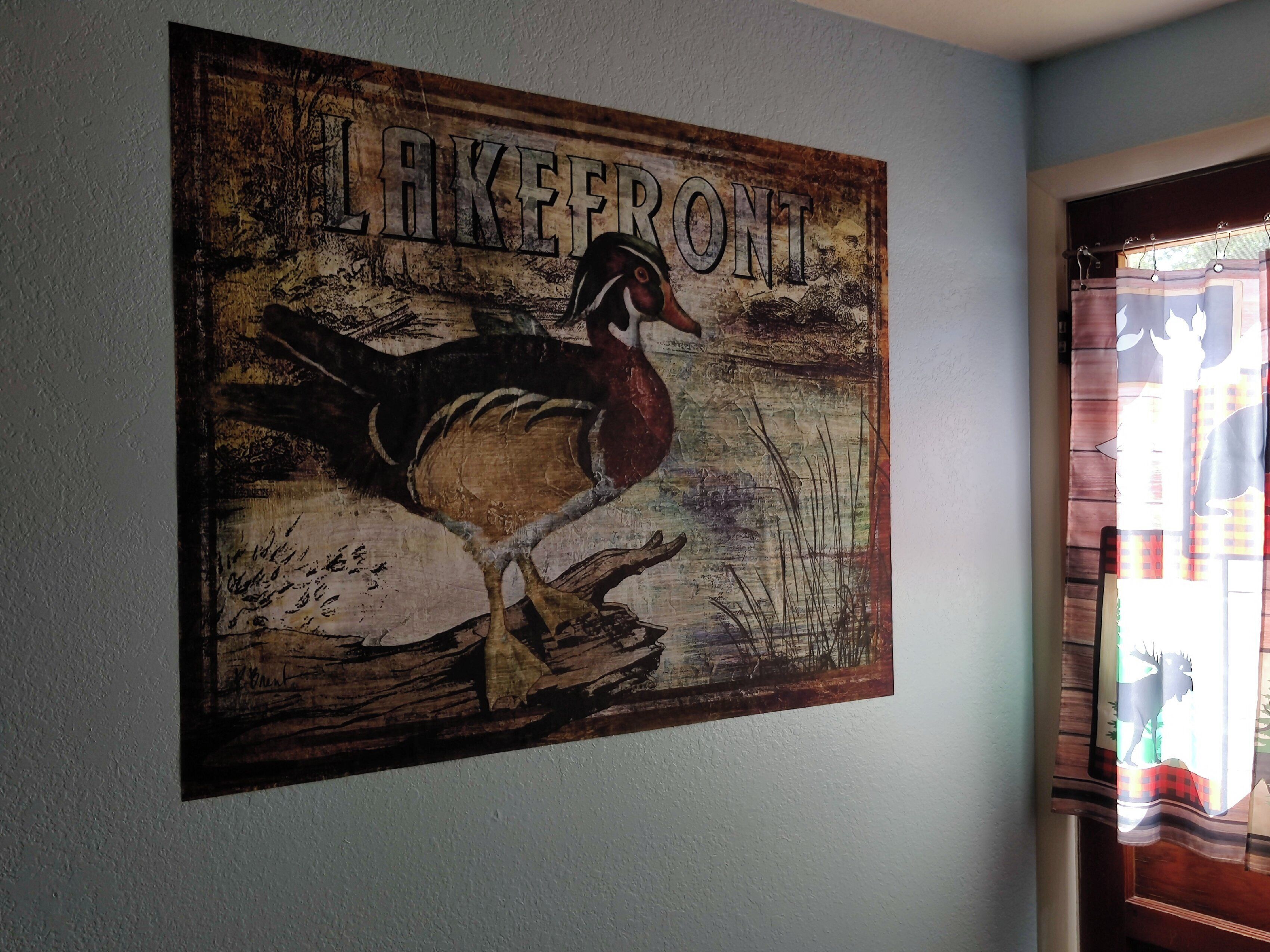 A wall with a rustic painting of a bird and the word "LAKEFRONT".