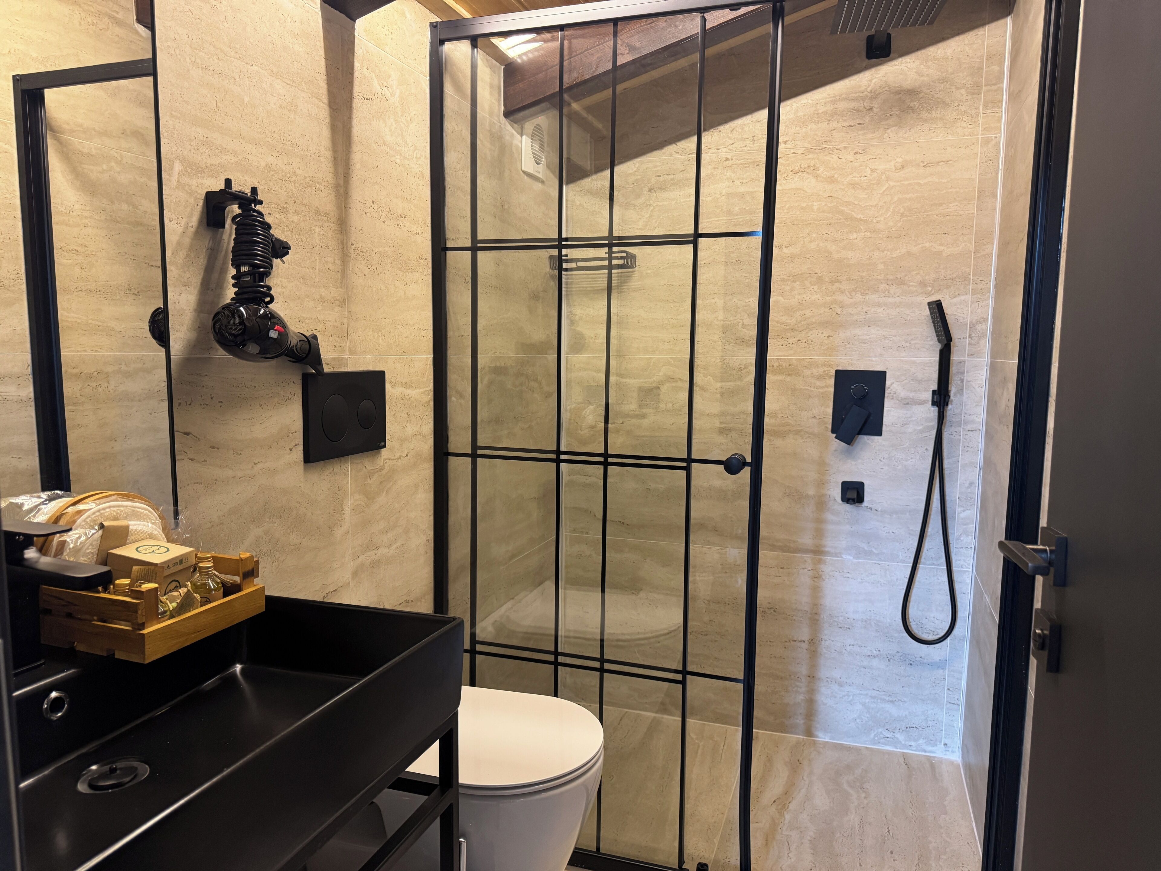 A modern bathroom with a shower enclosure, a toilet, and a sink area.