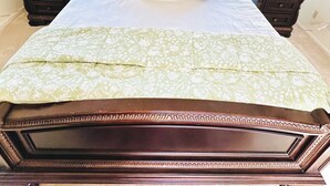 A bedroom with a wooden headboard, floral bedding, and teal curtains. - Elegant Master Suite w/ Walk-in Closet & Private Entry in Prime Location MGM! (Montgomery)