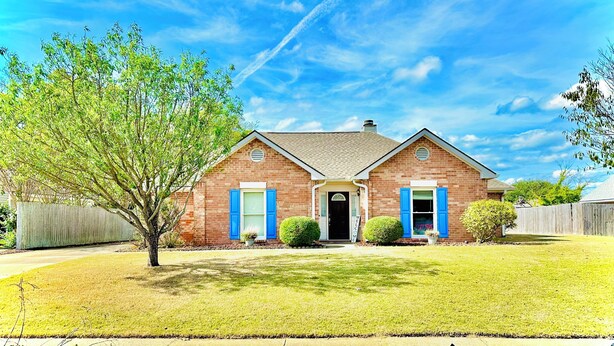 A two-story brick house with a front porch, a small tree, and a well-maintained lawn. - Elegant Master Suite w/ Walk-in Closet & Private Entry in Prime Location MGM! (Montgomery)