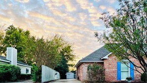A residential street with a concrete driveway leading to houses, surrounded by trees and a cloudy sky. - Elegant Master Suite w/ Walk-in Closet & Private Entry in Prime Location MGM! (Montgomery)