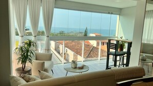 Un salón amplio con un balcón grande, un sofá, una mesa de centro y una silla.