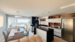 Una cocina moderna con una isla central, electrodomésticos integrados y un comedor con vistas.