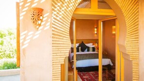 A room with a bed, a wall-mounted decorative object, and a patterned rug.