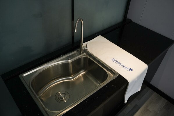 A stainless steel sink with a single faucet in a modern kitchen setting.