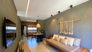 Un salon moderne avec un canapé, une table à manger et une cuisine en arrière-plan.