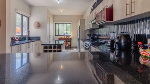 Una cocina moderna con encimeras negras, armarios de madera y una isla central.
