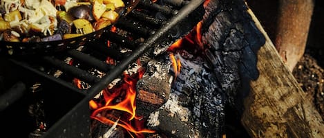 Una parrilla con comida cocinándose al aire libre.