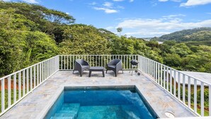 A rooftop pool with two chairs and a grill, surrounded by white railings and lush greenery. - Apartment #3 -1-bedroom apartment with WiFi, AC in tranquil Tarcoles (Tarcoles)