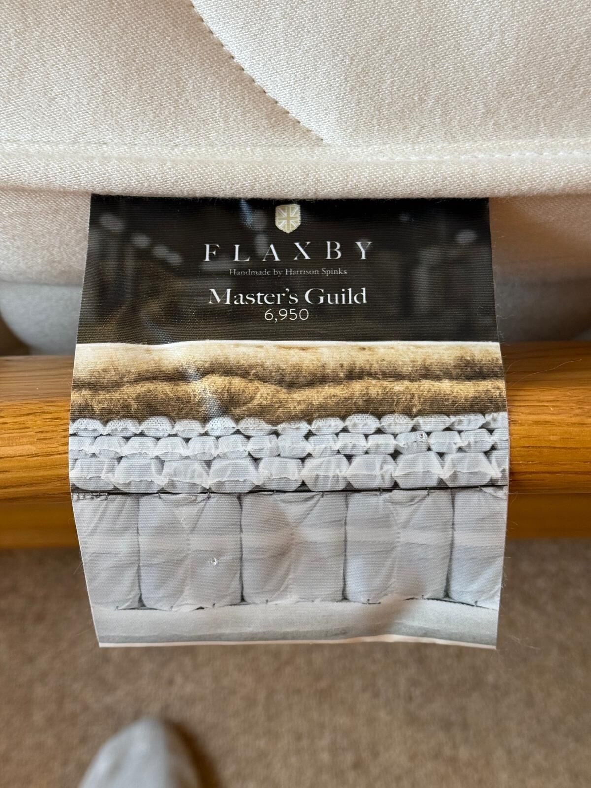 A fabric with a label reading "FLAXBY Handmade by Harrison Spinks Master’s Guild 6,950".