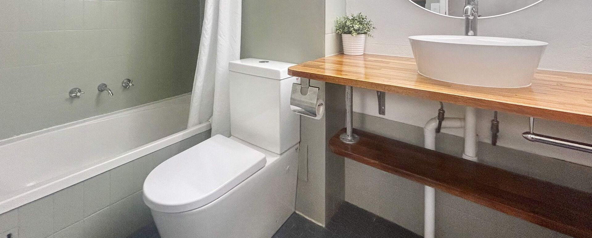 A modern bathroom with a toilet, bidet, and sink.
