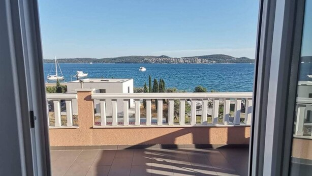 Un balcon avec vue sur la mer et les bateaux.