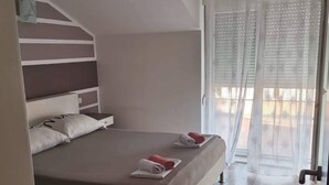 Une chambre à coucher avec un lit, une table de chevet et une fenêtre donnant sur un beau paysage.