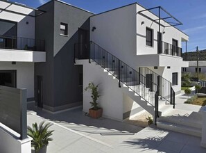 Stylish building with a striking contrast of white and dark grey exterior walls, featuring a clean-lined design and a prominent staircase.
