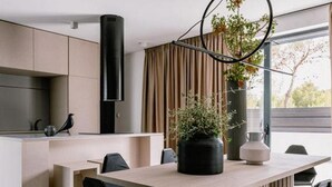 A modern kitchen with a central island, a dining area with a long table and chairs, and a large window with curtains. - Four Bedroom Villa with pool (Vodice)