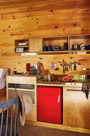 Frigorífico pequeño, placa de cocina y utensilios de cocina