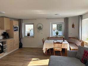 Un espace de vie compact comprenant un coin repas, une kitchenette et un canapé.