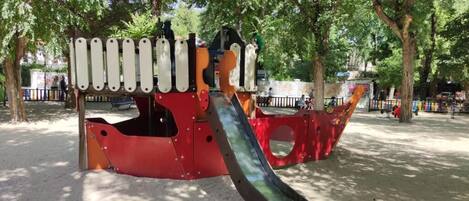Un parque infantil con un tobogán y estructuras para escalar.
