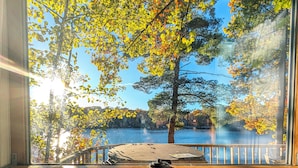 A wooden deck with a view of a lake and trees.