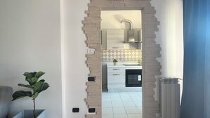 A modern kitchen with white cabinets, a built-in oven, and a grey radiator. - One stop away from FCO Airport and Fiera di Roma. Complete with all amenities (Lazio)