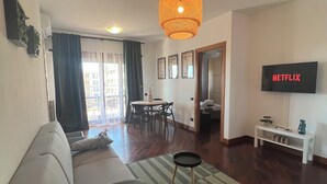 A living room with a sofa, a TV, and a dining area. - One stop away from FCO Airport and Fiera di Roma. Complete with all amenities (Lazio)