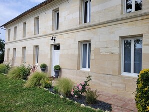 Un bâtiment en pierre de deux étages, doté d’une façade symétrique, de grandes fenêtres et d’une entrée centrale.