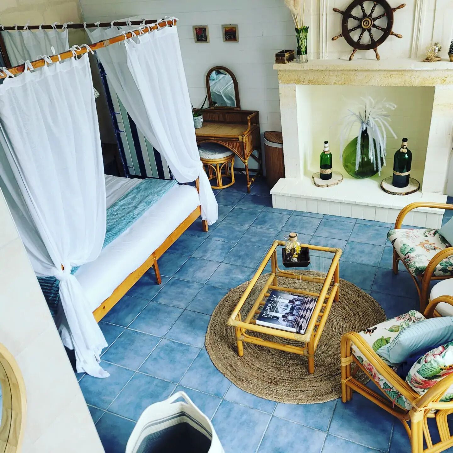 A room with a bed, a small table, a chair, and a fireplace.