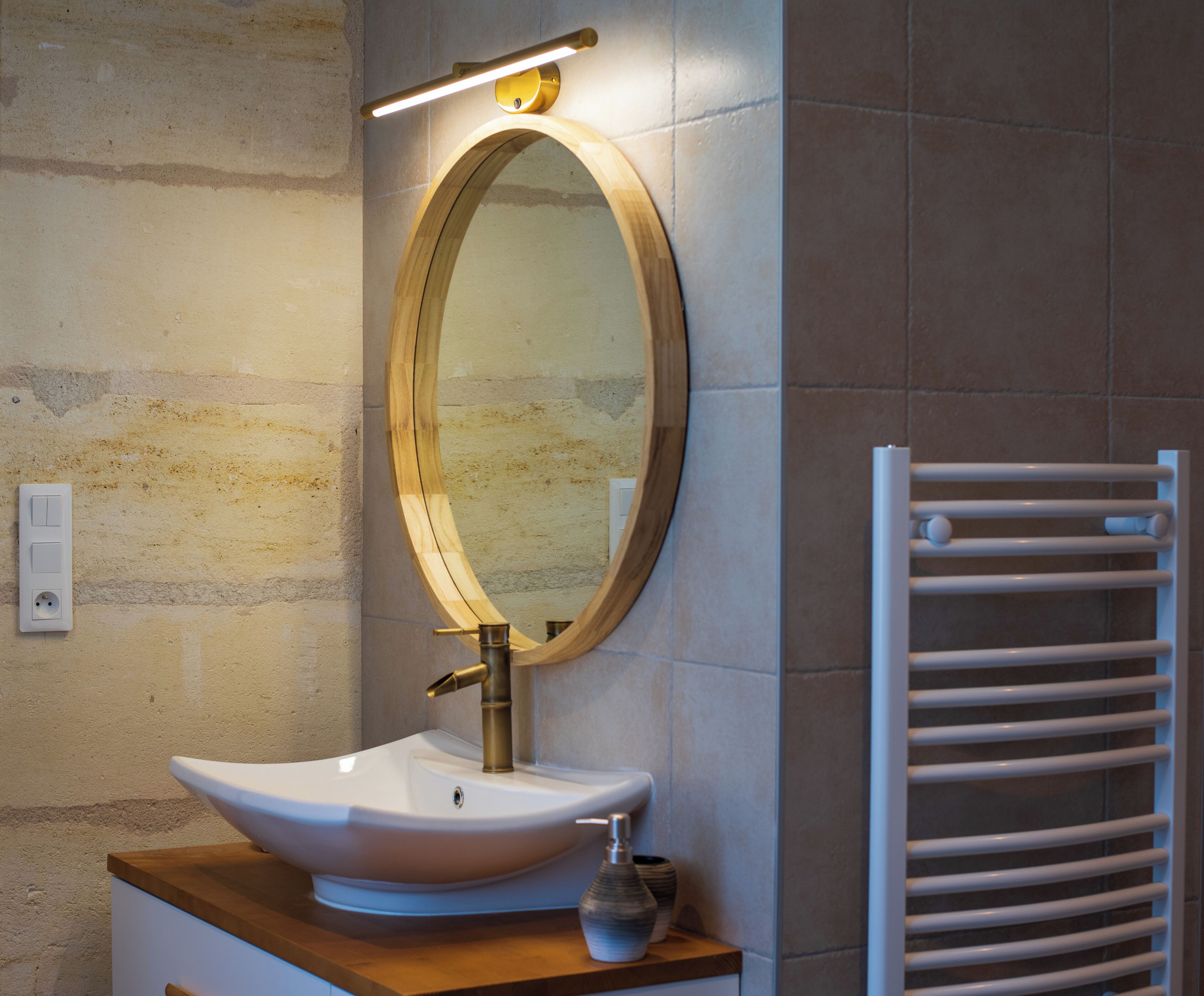 A bathroom with a white sink, a mirror, and a towel rack.