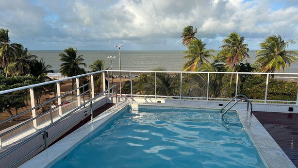 Una piscina con vista al océano y palmeras.
