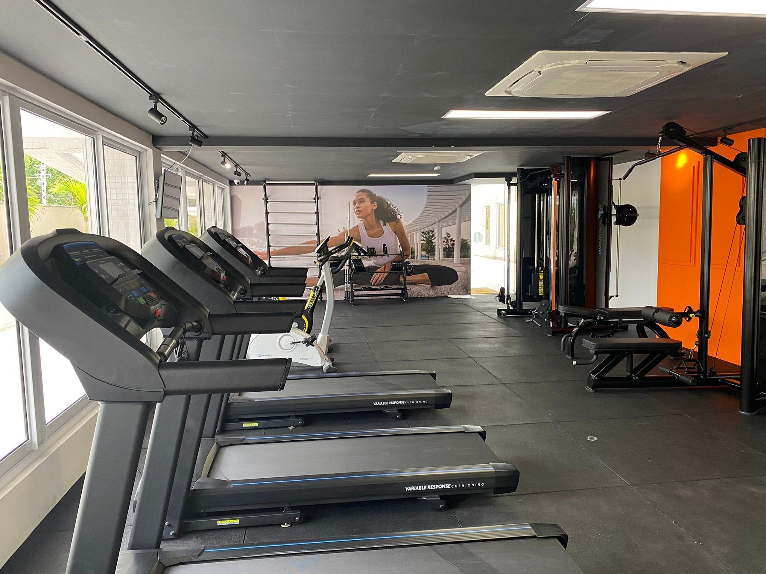 A gym with treadmills, a stationary bike, and weightlifting equipment.