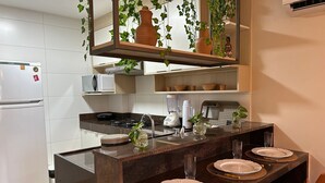 Una cocina moderna con una isla central, un refrigerador, un microondas y una estufa.