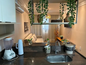 A compact kitchen with a built-in stove, a sink, and a countertop. - Bela Hospedagem - Puerto Ventura 103A (João Pessoa)