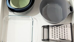 A kitchen counter with a glass baking dish, a colander, and a grater. - Clean 1 Bdr Apt w/ AC | Covered Parking | 539F1 (Rocklea)