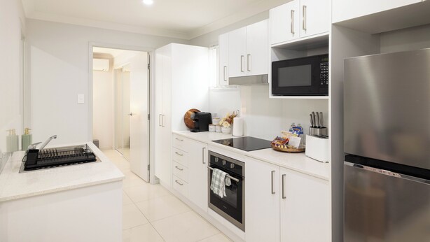 A modern kitchen with white cabinetry, a stainless steel refrigerator, a microwave, and a built-in oven. - 1 Bdr Apt w/ AC & Kitchen | Parking | 316F1 (Rocklea)
