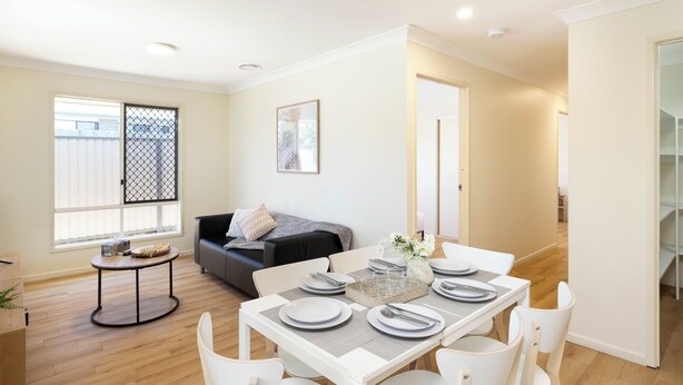 A dining area with a table set for four, a sofa, and a window with blinds. - Clean Acacia Ridge 1BR | Kitchen | 12AS1 (Acacia Ridge)