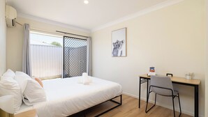 A bedroom with a bed, a desk, and a chair. - Clean Acacia Ridge 1BR | Kitchen | 12AS1 (Acacia Ridge)
