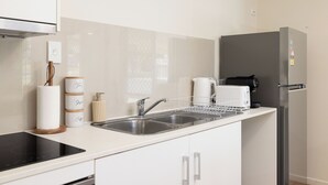 A modern kitchen with a stainless steel refrigerator, a built-in oven, and a double sink. - Acacia Ridge 3BR | Spacious & Easy Location | 12AS3 (Acacia Ridge)